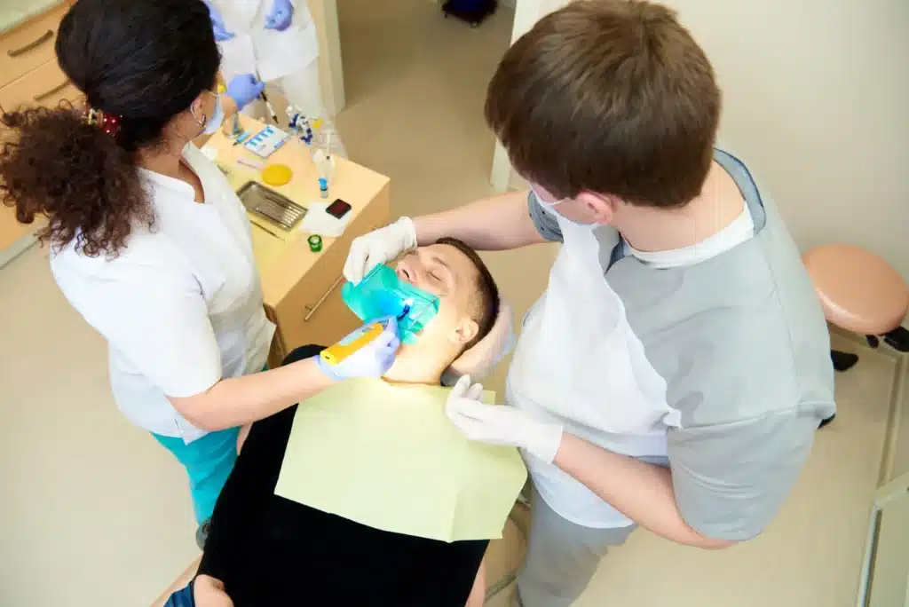 emergency dentist doing emergency dental treatment on patient.