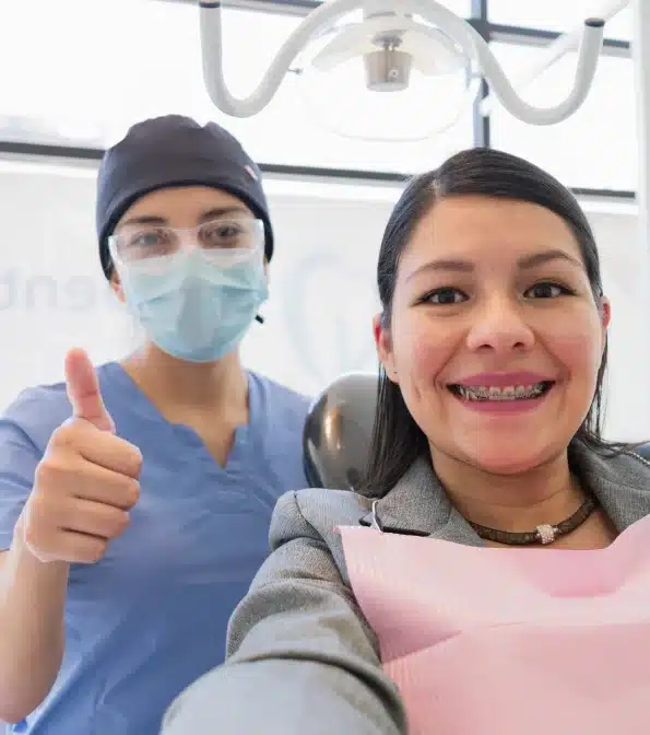 patient feeling good about her dental treatment just completed by the dentist behind her.