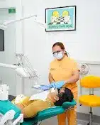 Dentist assisting a patient in a dental office setting.